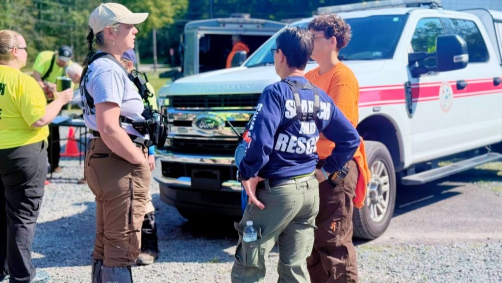 NESAR team members coordinating at an incident staging area beside a response vehicle